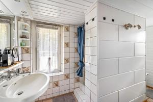 a white bathroom with a sink and a window at Bungalow an der Havel in Margarethenhof +24 photos