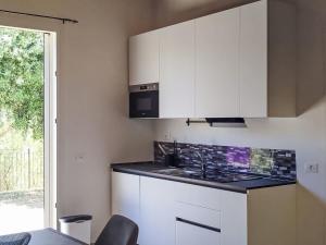 a kitchen with white cabinets and a sink and a window at Apartment in Riga by Interhome in Cisano sul Neva