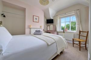 a bedroom with a white bed and a window at Finest Retreats - Artro View in Llanbedr