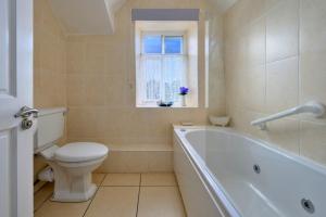 a bathroom with a toilet and a tub and a window at Finest Retreats - Artro View in Llanbedr +22 photos