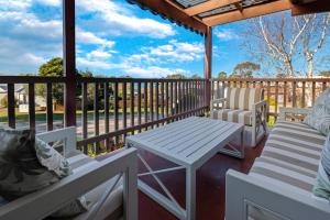 a porch with two chairs and a table on a deck at Paradise on Sheerwater in Paynesville