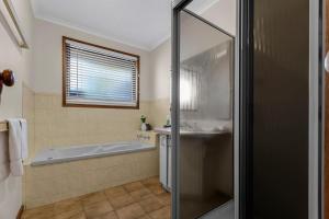 a bathroom with a bath tub and a shower at Paradise on Sheerwater in Paynesville +8 photos