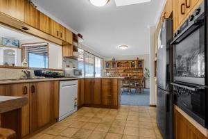a kitchen with wooden cabinets and a counter top at Paradise on Sheerwater in Paynesville