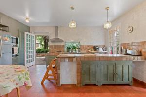 a kitchen with green cabinets and a counter top at Grand mas provencal in La Farlède