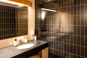 a bathroom with a sink and a shower with a mirror at Quinta De São José in Ervedosa do Douro