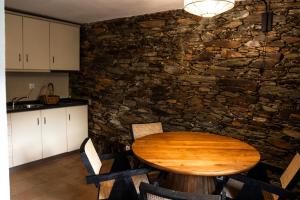 a wooden table in a kitchen with a stone wall at Quinta De São José in Ervedosa do Douro +36 photos