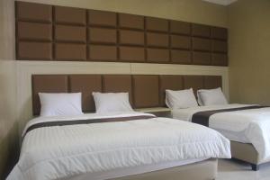 Postel nebo postele na pokoji v ubytování Cyka Raya Hotel