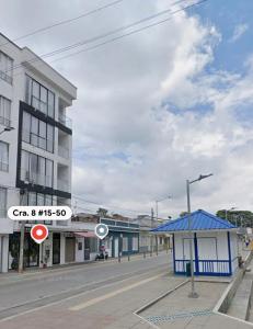 an empty street in a city with a blue building at Nogales apartahotel in Quimbaya