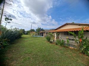 a house with a yard next to a building at Pouso Canarinho in Carrancas