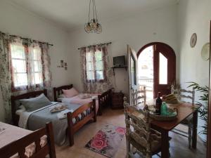 a bedroom with two beds and a table and a dining room at Lerios in Vrachonisída Savoúra