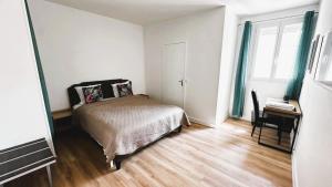 a bedroom with a bed and a desk and a window at Hotêl - Restaurant Le Bon Duc in Les Billaux