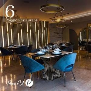 a restaurant with a table with blue chairs in a room at Hotel & Casino Internacional Valencia in Valencia