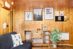 a living room with wood paneling and a couch at Betù Holiday Apartment in Castello di Fiemme