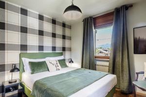 a bedroom with a large bed and a window at Betù Holiday Apartment in Castello di Fiemme