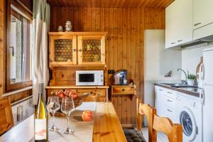 a kitchen with a table with wine glasses on it at Betù Holiday Apartment in Castello di Fiemme