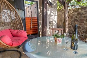 a glass table with a bottle of wine and a chair at סיקרט נס ספא in Had Nes