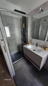 a bathroom with a white sink and a shower at La Terrazza Bella Sicula in Furci Siculo