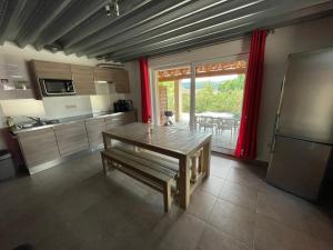 a kitchen with a wooden table and a large window at Villa Vallon Pont d'Arc in Vallon-Pont-dʼArc