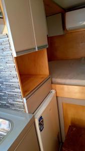 a small kitchen with a refrigerator and a sink at Van Home in Lavrinhas