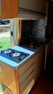 a kitchen with a stove and a sink at Van Home in Lavrinhas