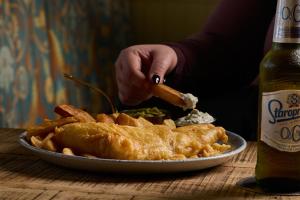 a plate of food on a table next to a bottle of beer at The Dean Court in York