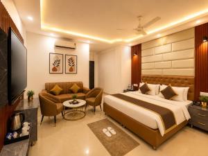 a hotel room with a bed and a couch at Hotel Kasa Stays Premier - Peeragarhi Metro Station in New Delhi