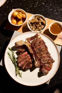 a plate of meat and other foods on a table at Hotel Mona Plaza in Belgrade