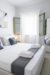 a white bedroom with two beds and a mirror at Villa Selina 2 - Etheras Properties in Kythira +52 photos