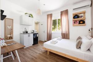 a white room with a bed and a table at Localz House- Trumpeldor Beach in Tel Aviv +85 photos