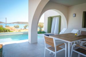a dining room with a table and a swimming pool at Villa Selina 2 - Etheras Properties in Kythira