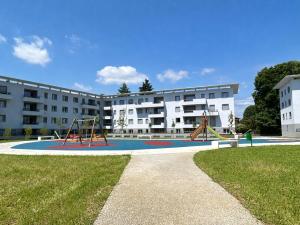 an apartment complex with a playground in front of a building at Malpensa Airport Apartment - 9 min to MXP - Free Parking in Somma Lombardo