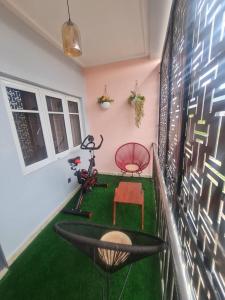 a room with a green floor with a treadmill and a chair at Aprils homes & apartments in Ankuru