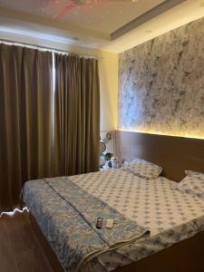 a bedroom with a bed and a window with curtains at Corestay in Greater Noida