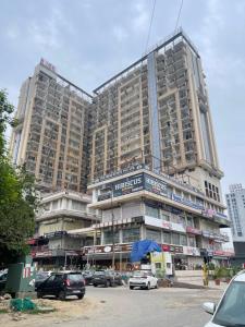 a large building with cars parked in front of it at Corestay in Greater Noida