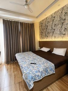 a bedroom with a bed with a blue comforter at Corestay in Greater Noida