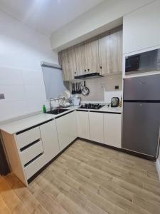 a kitchen with white cabinets and stainless steel appliances at Aprils homes & apartments in Ankuru