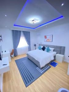 a bedroom with a large bed with a blue ceiling at Aprils homes & apartments in Ankuru