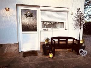 a door to a house with a bench next to it at Jázmin apartmanok in Pogány