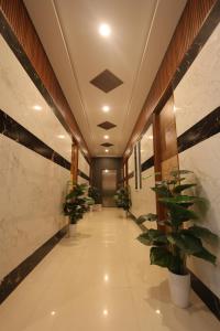 a hallway with potted plants in a building at Anand Legacy in Nelamangala