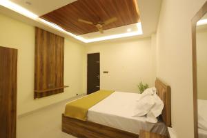 a bedroom with a bed with a ceiling fan at Anand Legacy in Nelamangala
