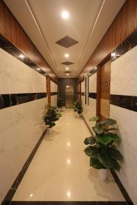 a hallway with potted plants in a building at Anand Legacy in Nelamangala