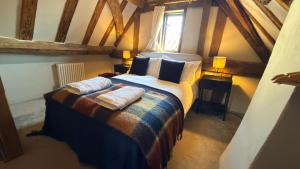 a bedroom with a large bed with two pillows at Taylour House - Edenbridge, sleeps 10, historic, unique yet modern in Kent