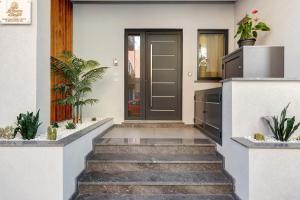 a front door of a house with stairs and plants at La Rocca D’Amuri in Partinico