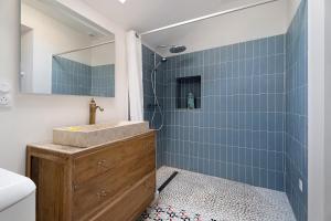a bathroom with a sink and a shower with blue tiles at Chambre de garel in Le Minihic-sur-Rance +13 photos