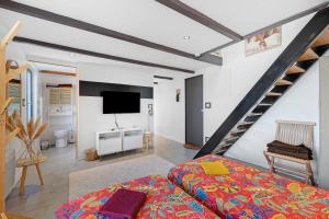 a bedroom with a bed and a tv and a staircase at Charmant appartement pour 4 in Saint-Jean-de-Liversay