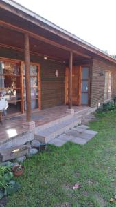 a wooden house with a porch and a patio at Alojamiento Parcela El Aromo in Paine