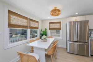 a kitchen with a white table and a refrigerator at Mermaid Lane #1 in Brighton Beach
