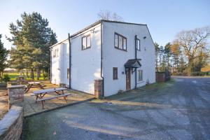 a white building with a picnic table next to it at Villa Farm York in York