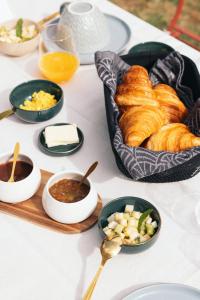 a table with croissants and other dishes of food at Maison Pistache in Le Dorat