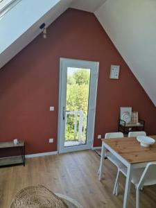 a living room with a table and a window at La maison des Hirondelles 2 in Fort-Mahon-Plage